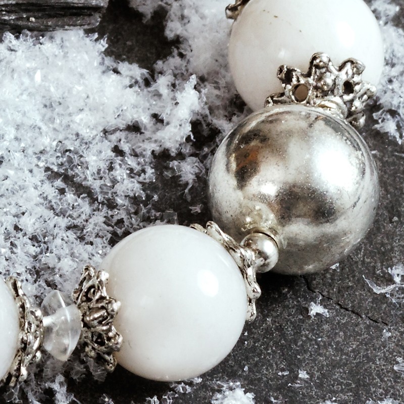 Armband Schneejade, Nahaufnahme der Schneejade-Perlen neben der silberfarbenen Metallperle Armband Schneejade, Nahaufnahme der Schneejade-Perlen neben der silberfarbenen Metallperle