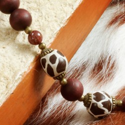 Halskette Jala, Detailansicht der gemusterten Glasperlen, Metallperlen, Granatkugeln und der braunen Holzperlen links