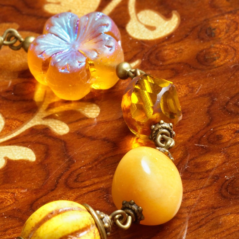 Armband Bernsteinschatz, Detailansicht Glasblüte, Glasperle mit Helix-Schliff, Orangencalcit-Nugget und Howlith-Perle