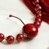 Schmuck-Set Kirschsaison, Detailansicht der Kunststoff-Kirsche inmitten roter Muschelkernperlen