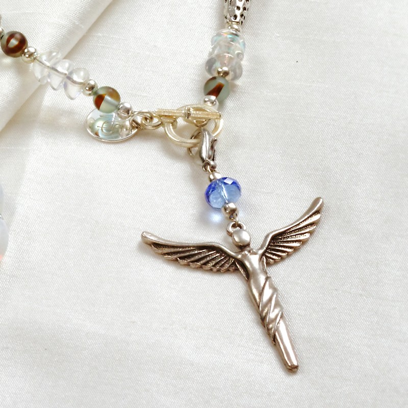 Schmuck-Set Nike, Nahaufnahme vom abnehmbaren Kettenanhänger mit versilberter Engel-Figur Schmuck-Set Nike, Nahaufnahme vom abnehmbaren Kettenanhänger mit versilberter Engel-Figur