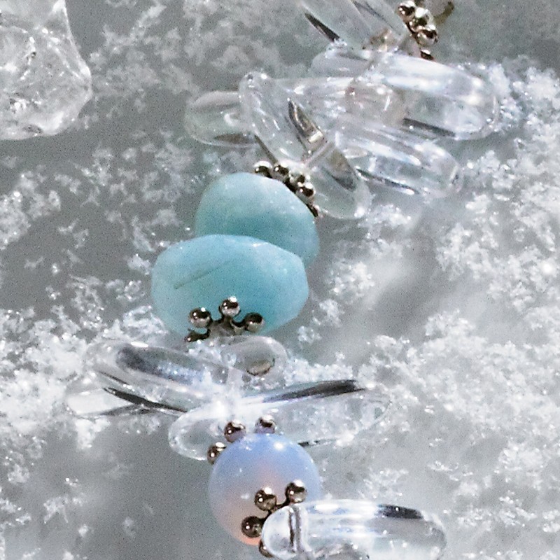 Halskette Schneekönigin, Nahaufnahme der Bergkristall-, Aquamarin-, Chalcedon- und Metallperlen links Halskette Schneekönigin, Nahaufnahme der Bergkristall-, Aquamarin-, Chalcedon- und Metallperlen links