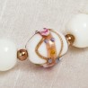 Armband Wedding Cake, Nahaufnahme einer verzierten "Wedding Cake"-Perle neben roségoldenen Metall- und weißen Glasperlen