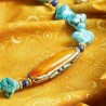 Halskette Norbu, Nahaufnahme der Focalperle aus bernsteinfarbenem, mit Intarsien verziertem Resin
