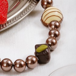 Halskette Süße Verführung, Nahaufnahme der Kunststoff-Pralinen und Muschelkernperlen rechts