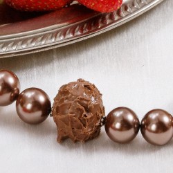 Halskette Süße Verführung, Nahaufnahme der Kunststoff-Pralinen und Muschelkernperlen vorn