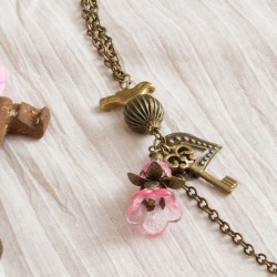 Longkette Schlüssel zum Herzen, Nahaufnahme Metallanhänger, Kunststoff- und Glasperlen links