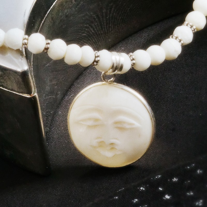 Halskette Mondgesicht, Nahaufnahme des geschnitzten Mondgesicht-Anhängers aus weißem Knochen