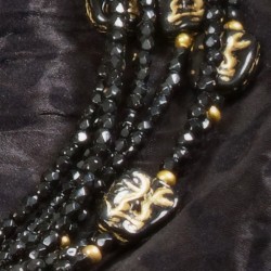 Halskette Maskenball, Nahaufnahme der goldverzierten Maskenperlen